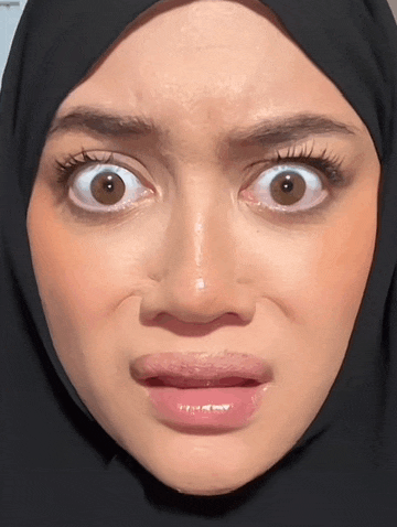 a woman wearing a black hijab makes a funny face