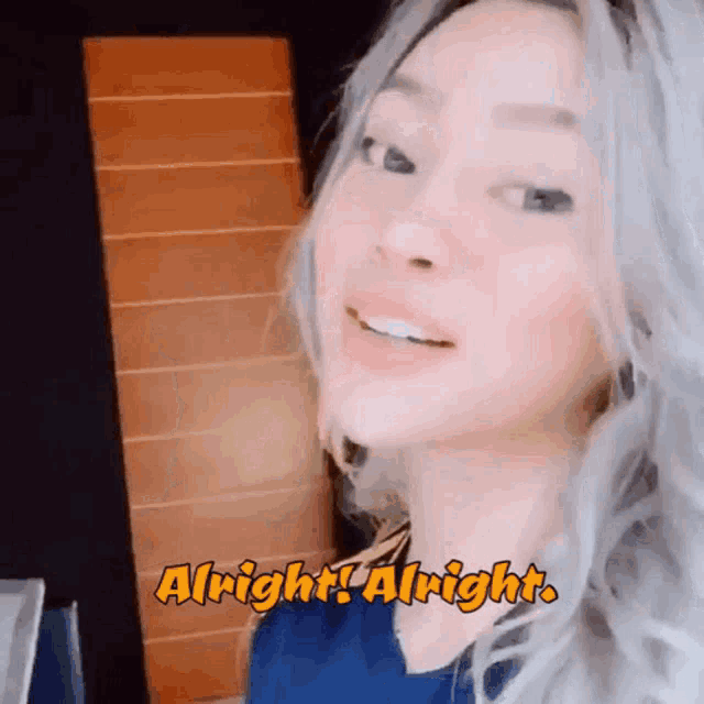 a woman is smiling with the words alright alright written on her face