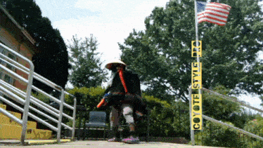 a person in a samurai costume is standing in front of a sign that says coyote style pro