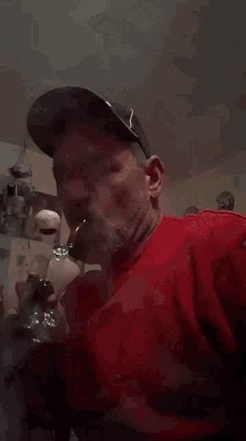 a man in a red shirt is smoking a cigarette