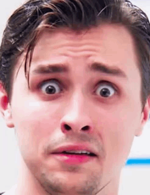 a close up of a man making a funny face with his mouth open .