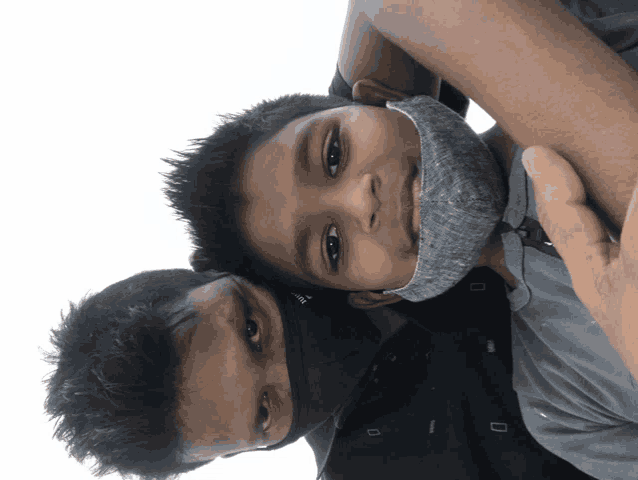 a young boy wearing a mask is being held by a man