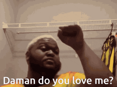 a man holds up his fist in a closet and says " daman do you love me "