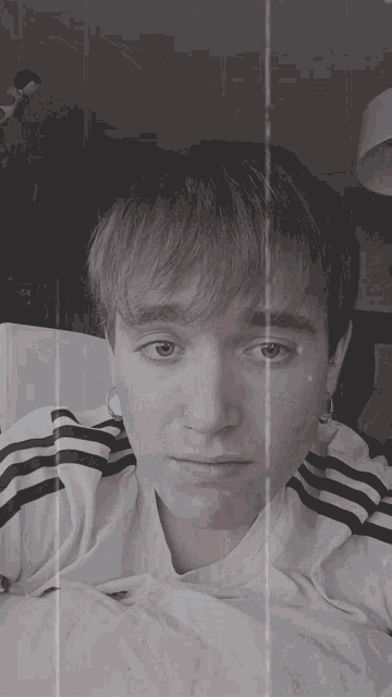 a black and white photo of a young man laying on a couch