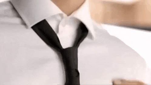 a man wearing a white shirt and a black tie is taking a picture of himself .