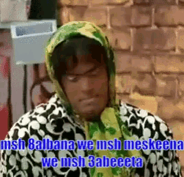 a man wearing a green scarf around his head with the words " we wish 3abeeta " below him