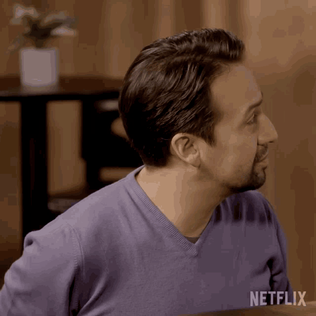 a man wearing a purple sweater with the word netflix on the bottom right