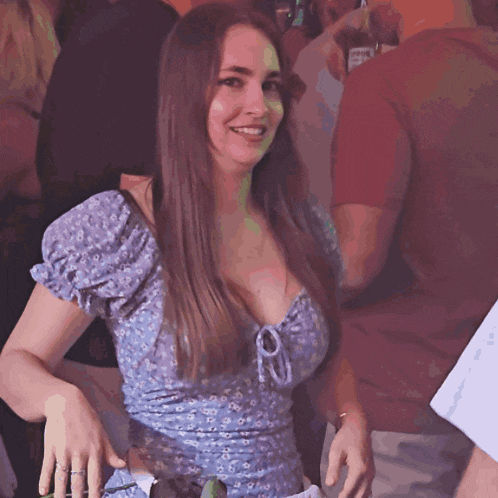 a woman in a blue dress is smiling in a crowd
