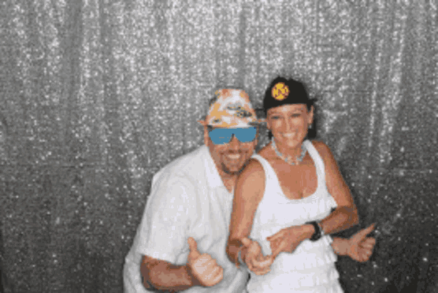 a man and woman are posing for a picture in front of a sequined backdrop