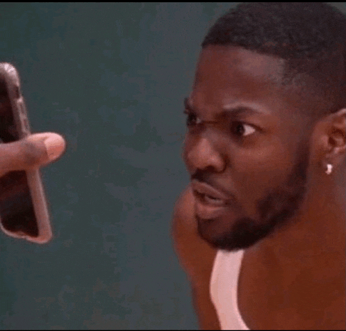 a man is taking a picture of another man with his cell phone .
