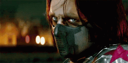 a close up of a man wearing a mask and looking at the camera .