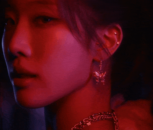 a close up of a woman 's face with red lights behind her