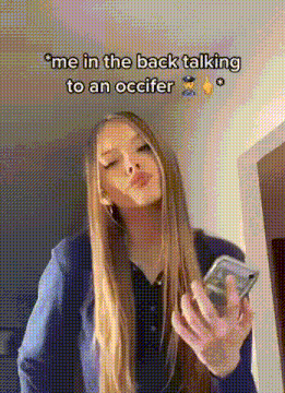 a woman with long blonde hair is holding a cell phone and talking to a police officer .