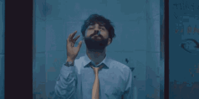 a man smoking a cigarette in front of a wall that says kara