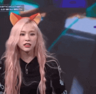 a woman wearing a cat ear headband looks at the camera