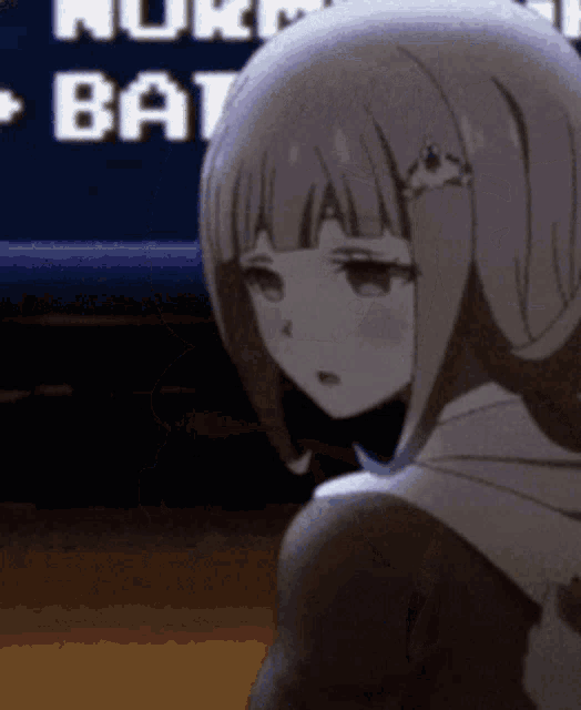 a girl is sitting in front of a sign that says ' a ' on it .