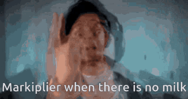 a man covering his face with his hands and the words markiplier when there is no milk written below him .