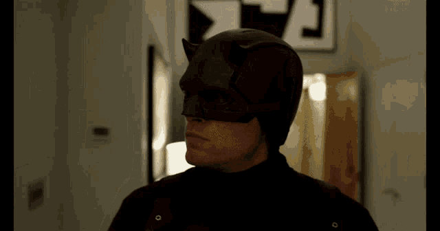 a man in a daredevil costume stands in front of a sign that says a