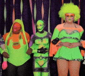 a group of people standing next to each other with one wearing a neon green outfit