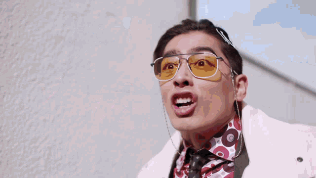 a man wearing yellow sunglasses with his mouth open