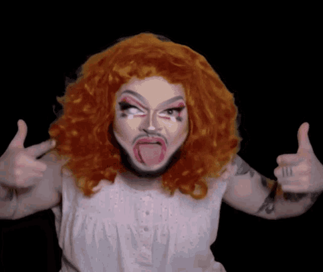 a person with red hair and a beard is giving a thumbs up