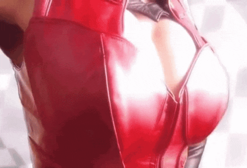 a close up of a woman 's breasts in a red latex bra .