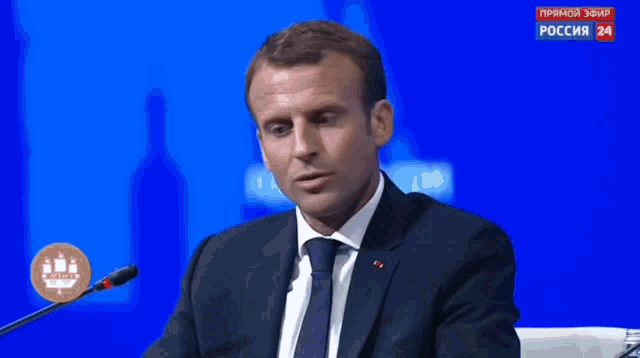 a close up of a man 's face with a blue background that says ' russia 24 ' on the bottom
