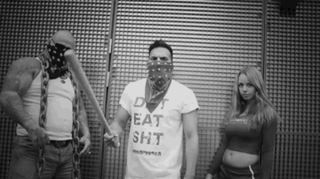 a man wearing a shirt that says do n't eat shit holds a bat
