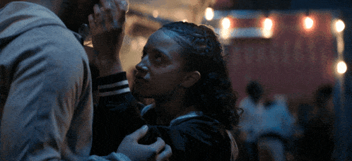 a man holds a woman 's hand in front of a sign that says ' netflix ' on it