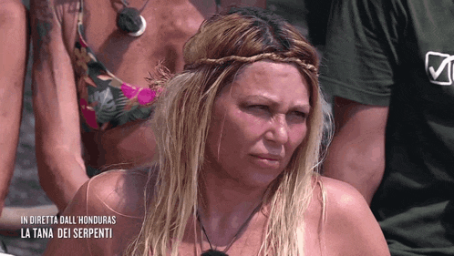 a woman with blonde hair and a braided headband with the words in diretta dall ' honduras la tana dei serpenti