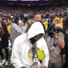 a man in a white hoodie is standing in front of a crowd