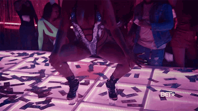 a woman is dancing on a dance floor with bet on the bottom right