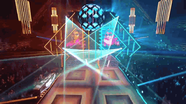 a stage with a large sphere in the middle of it and a woman behind it