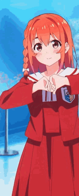 a girl in a red school uniform is making a heart with her hands .