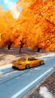 a yellow car is driving down a road with trees on the side of it .