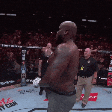 a man stands in a boxing ring with a sign that says serve your way