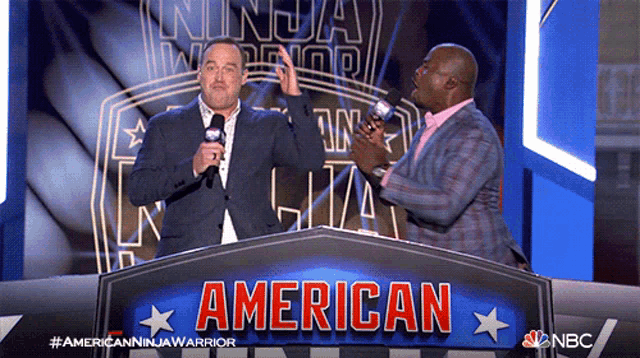 two men standing in front of an american sign