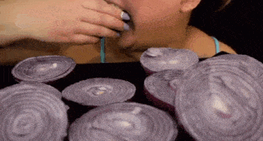 a woman is eating onions with a straw .