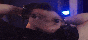 a man wearing headphones has his hands behind his head