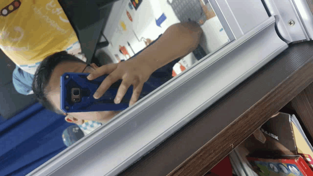 a person taking a picture of themselves in a mirror with a tp-link box in the background
