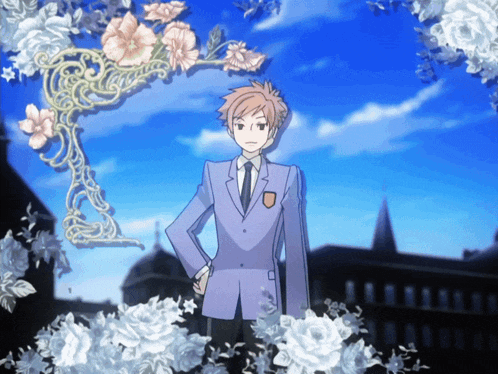 a boy in a suit and tie is standing in front of a floral arch