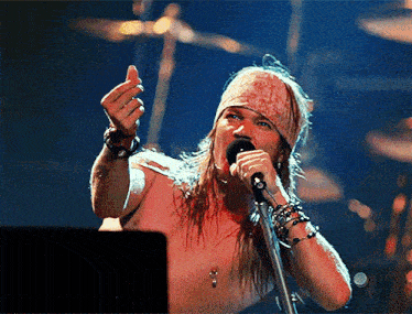 a man with long hair singing into a microphone
