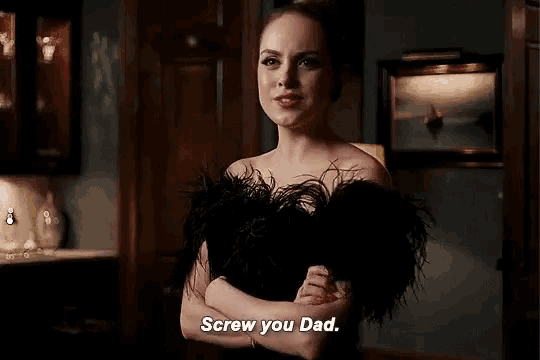 a woman in a black dress is standing in a room with her arms crossed and says `` screw you dad . ''