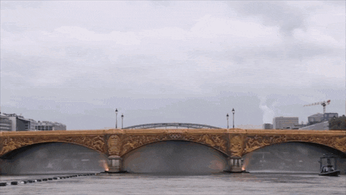 a bridge over a body of water with a boat passing underneath it