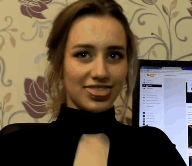 a woman stands in front of a computer screen which says youtube on it