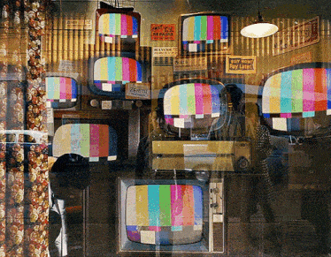 several old televisions are in a room with a sign that says east tv repairs