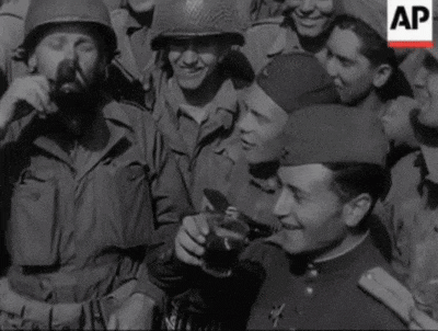 a group of soldiers are gathered around a man holding a coca cola cup