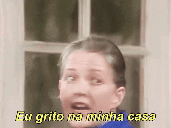a woman is standing in front of a window and says eu grito na minha casa .