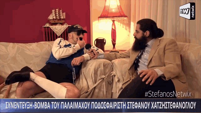 two men are sitting on a couch and one is holding a microphone with the hashtag #stefanosnetwix