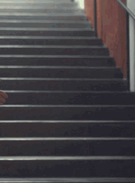 a woman in a newspaper print top is standing on stairs